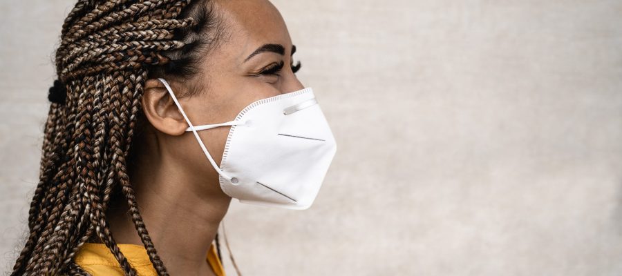 African woman with braids wearing face medical mask - Young girl using facemask for preventing and stop corona virus spread - Healthcare medical and youth millennial people concept