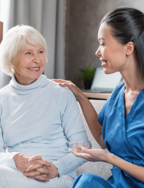 Nurse assisting with elderly woman at home