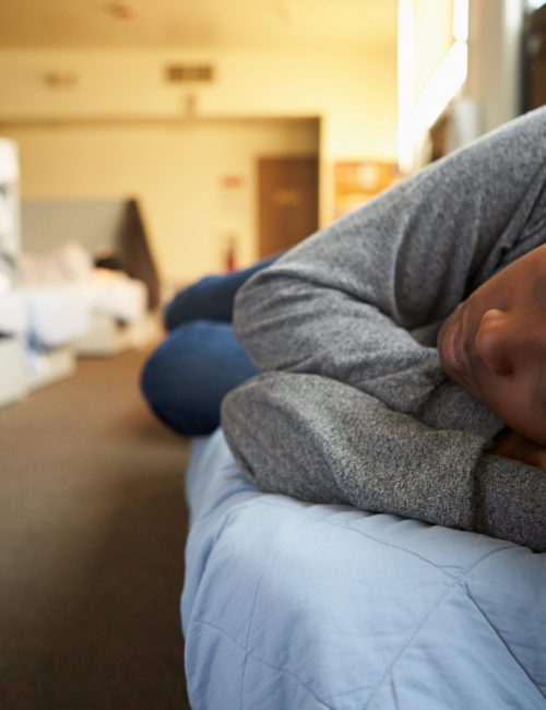 Women Lying On Beds In Homeless Shelter