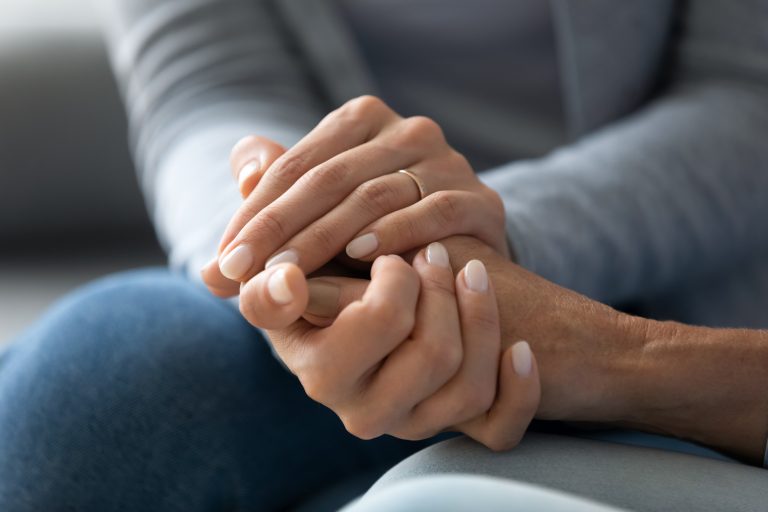 Hands held in a supportive conversation