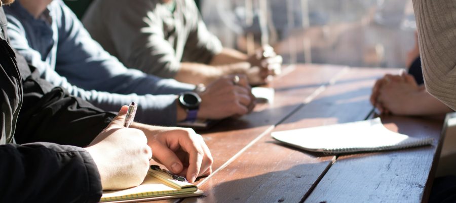 People discuss notes and documents around a shared table