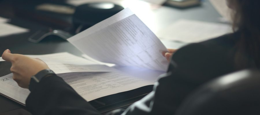 A woman reviews a document at a table