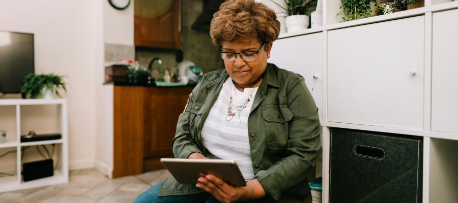 An older woman uses a tablet at home