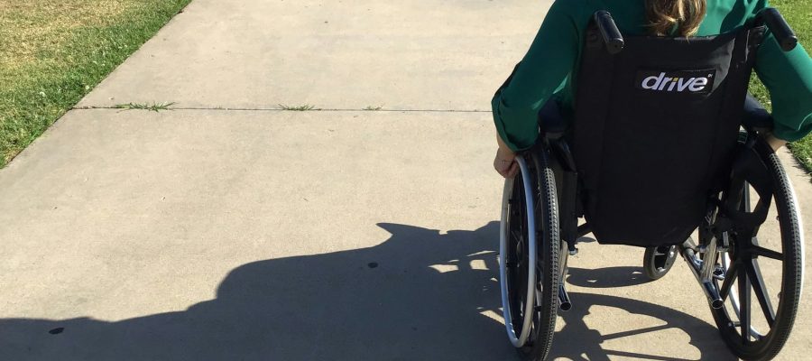 A person uses a wheelchair on an outdoor path