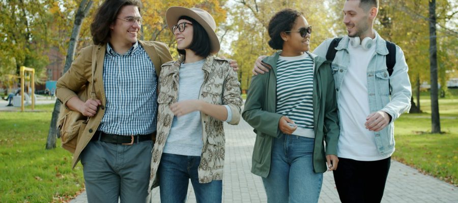 Four adults walk together along a path outdoors