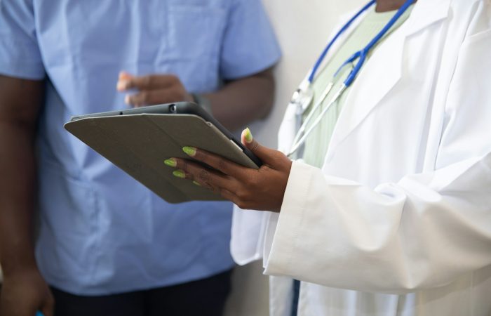 A clinician and another adult look at a tablet together