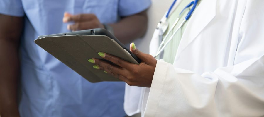 A clinician and another adult look at a tablet together