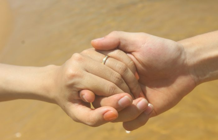 Two people hold hands