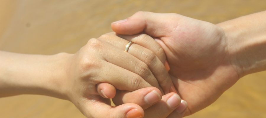 Two people hold hands